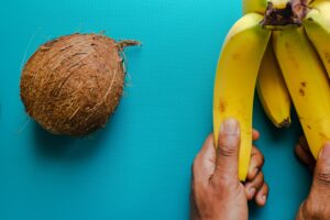 yellow banana fruit beside brown coconut fruit