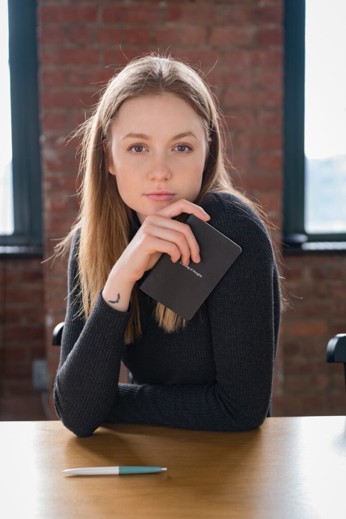 woman wearing black sweatshirt sitting beside table