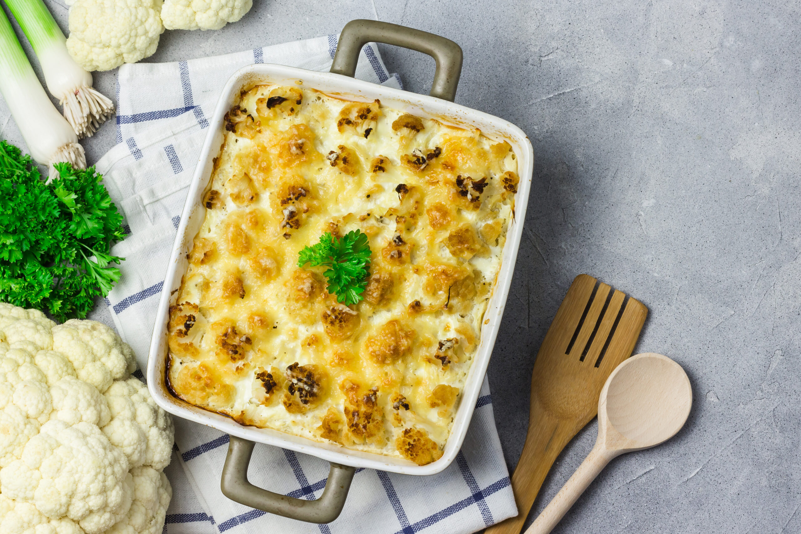 Cauliflower casserole on concrete background. Cheesy cauliflower casserole. Vegan cauliflower bake. chicken cauliflower casserole.