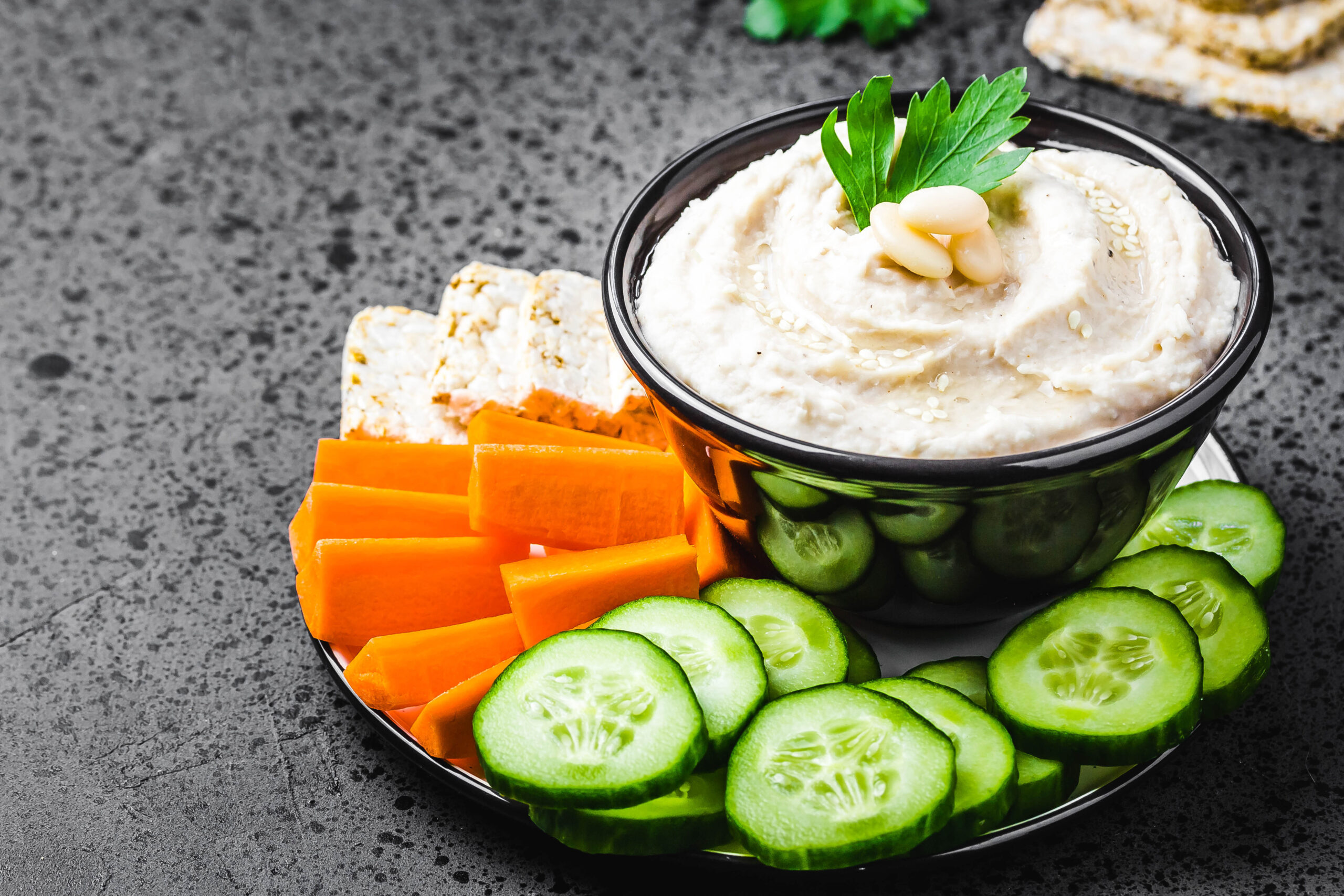 white bean dip on dark concrete background. Selective focus, space for text.