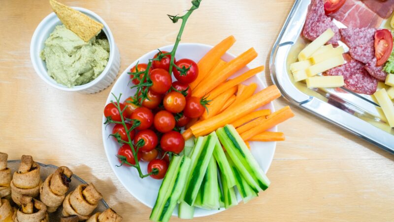 slices of carrots, zucchini, and cherry tomatoes on round white ceramic bowl