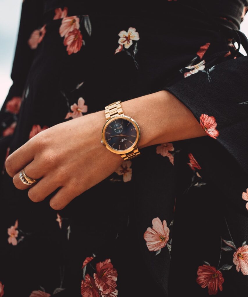 person wearing gold and black analog watch