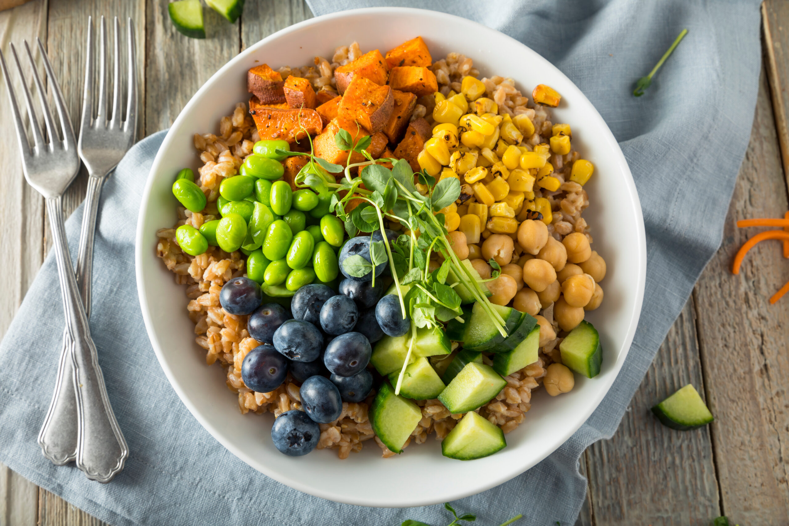 Raw Organic Healthy Buddha Bowl with Farro Spinach Edamame and Cucumber