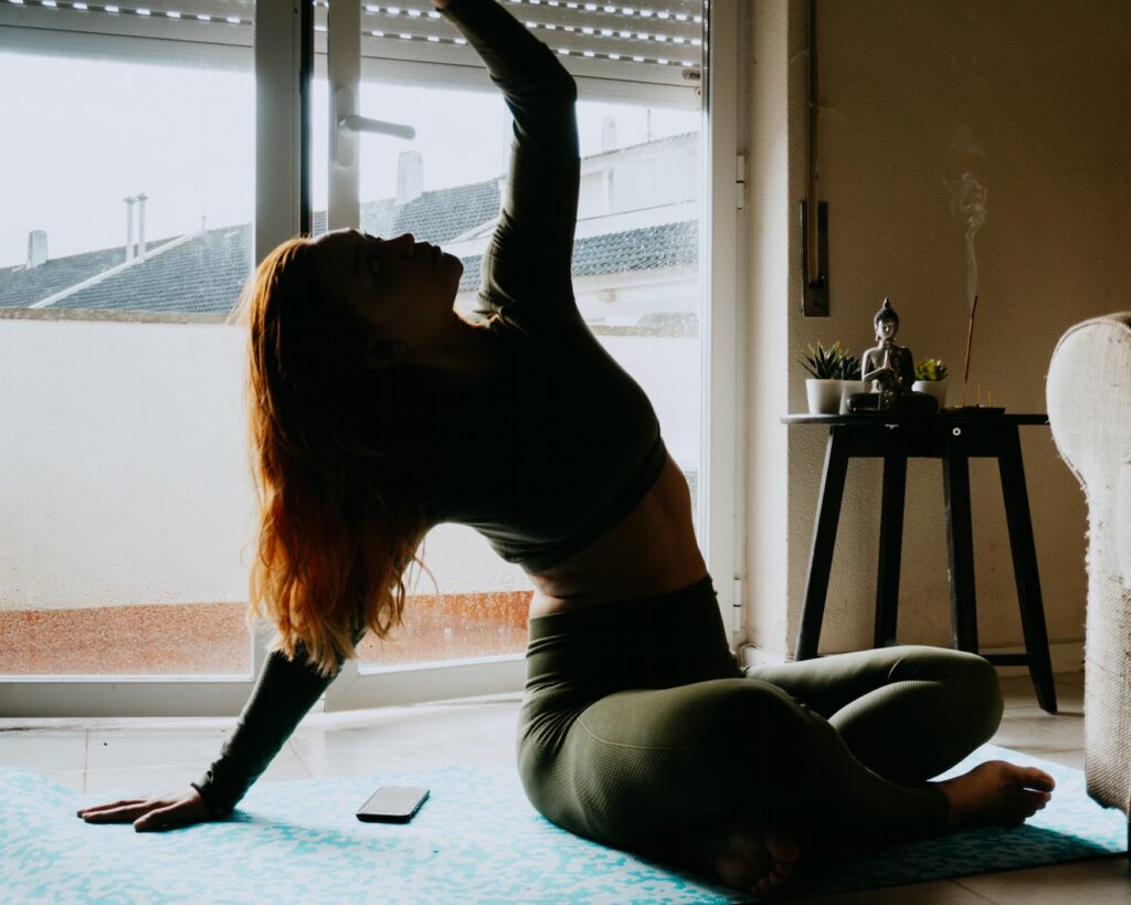 woman in black tank top and black leggings kneeling on floor