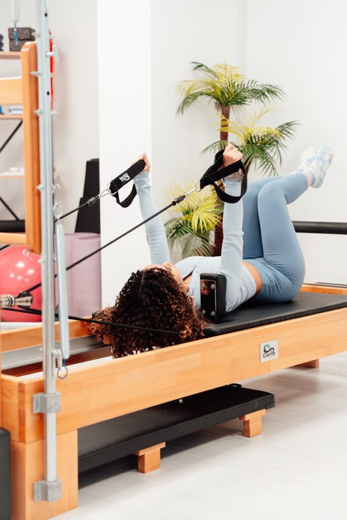 a woman in a gym doing exercises on a pilates machine