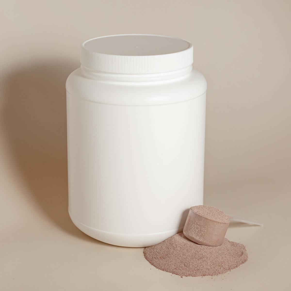 Simple white container with protein powder and scoop, ideal for health and fitness themes.